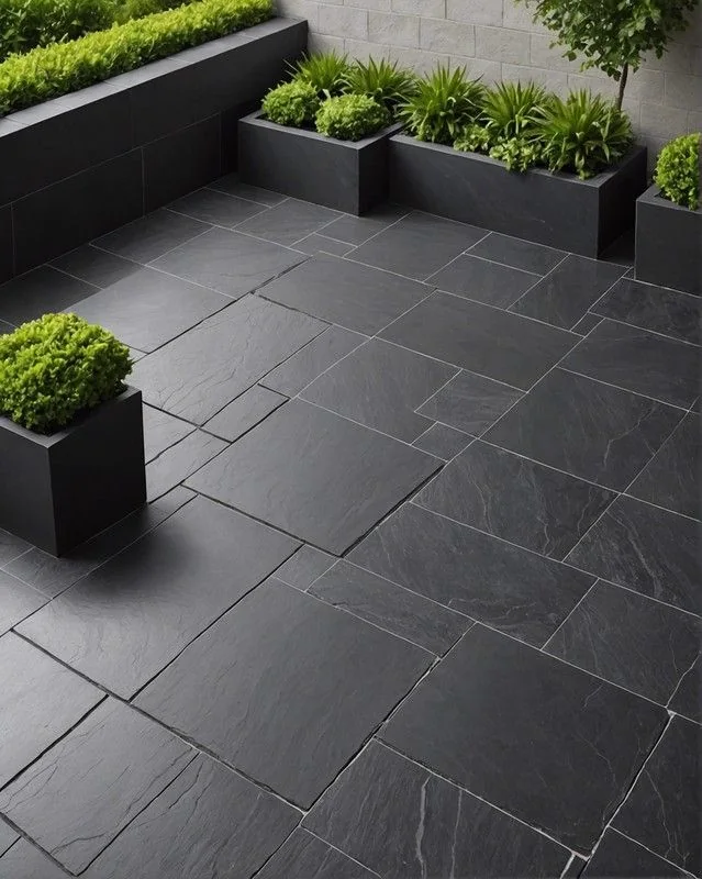 Outdoor terrace laid with large dark slate paving tiles